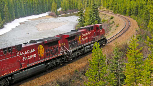 Canadian Pacific double locomotives rounding bend in the Bow river. Alberta.