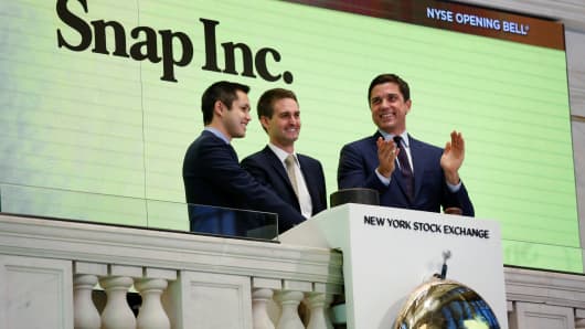 Snap cofounders Evan Spiegel (C) and Bobby Murphy ring the opening bell of the New York Stock Exchange (NYSE) with NYSE Group President Thomas Farley shortly before the company's IPO in New York, U.S., March 2, 2017.