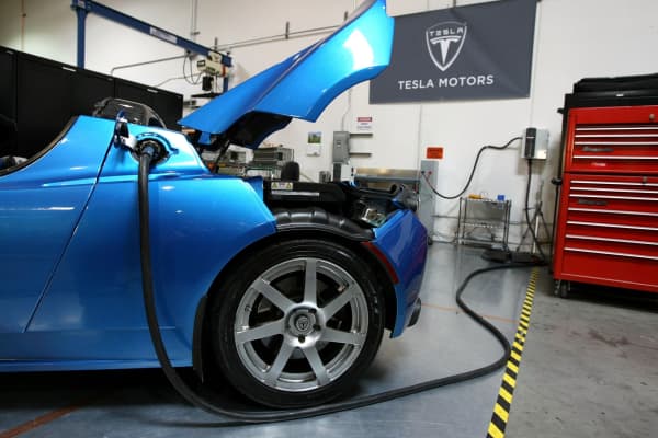 A power cable is seen plugged into a Tesla Roadster at the former Tesla headquarters in San Carlos.