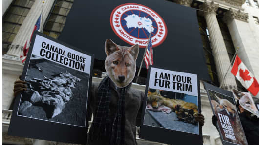 Wearing coyote masks and business suits and waving signs against Canada Goose and their use of fur, PETA members gather outside the New York Stock Exchange on March 16, 2017 to protest as Canada Goose makes its initial public offering in New York.