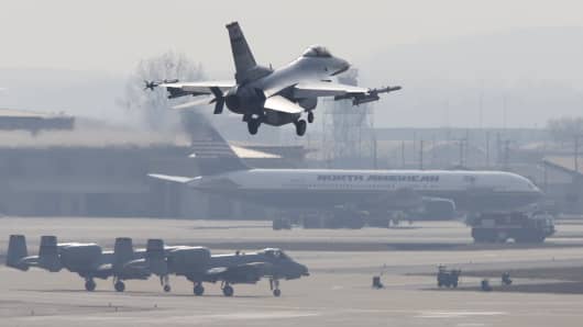 A F-16 fighter jet (top) belonging to the U.S. Air Force comes in for a landing at a U.S. air force base in Osan, south of Seoul.