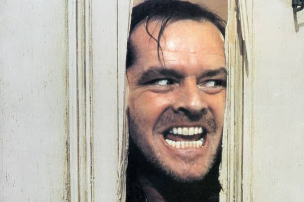 Jack Nicholson peering through axed in door in lobby card for the film 'The Shining', 1980.