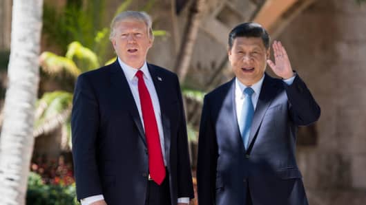 Chinese President Xi Jinping (R) waves to the press as he walks with U.S. President Donald Trump at the Mar-a-Lago estate in West Palm Beach, Florida, April 7, 2017.