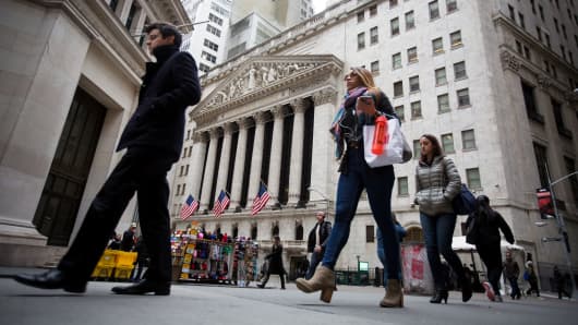 Pedestrians walk past the New York Stock Exchange.