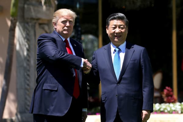 President Donald Trump (L) and China's President Xi Jinping shake hands while walking at Mar-a-Lago estate after a bilateral meeting in Palm Beach, Florida, April 7, 2017.