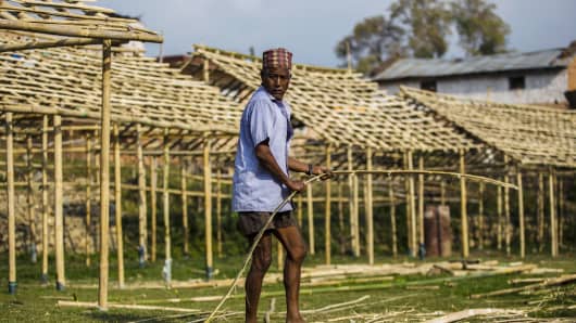 A volunteer prepares bamboo poles while building makeshift school buildings in Champi, Kathmandu Valley, Nepal, on May 29, 2015.