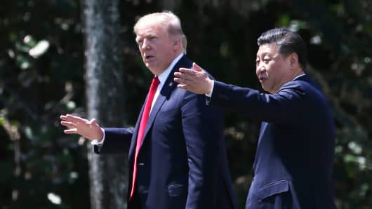 President Donald Trump (L) and China's President Xi Jinping walk along the front patio of the Mar-a-Lago estate after a bilateral meeting in Palm Beach, Florida, April 7, 2017.