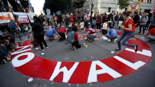 Protesters paint a mural on the street during a May Day demonstration outside of a U.S. Immigration and Customs Enforcement (ICE) office on May 1, 2017 in San Francisco, California.