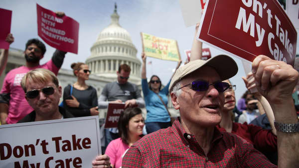Activists hold signs during a Stop 'Trumpcare' rally in front of the Capitol in Washington, DC.