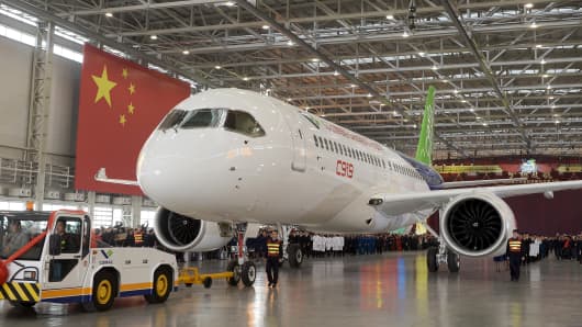 The first C919 passenger jet made by the Commercial Aircraft Corporation of China (Comac) is pulled out next to a Chinese national flag during a news conference at the company's factory in Shanghai, Nov. 2, 2015.