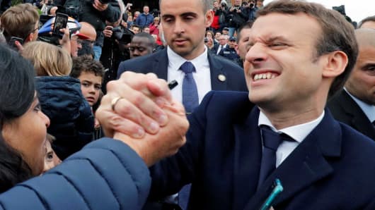 French presidential election candidate Emmanuel Macron, head of the political movement En Marche !, or Onwards ! greets supporters as leaves a polling station during the the second round of 2017 French presidential election, in Le Touquet, France, May 7, 2017.