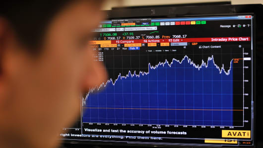A journalist looks at the Intraday Price Chart showing London's FTSE 100 Index.