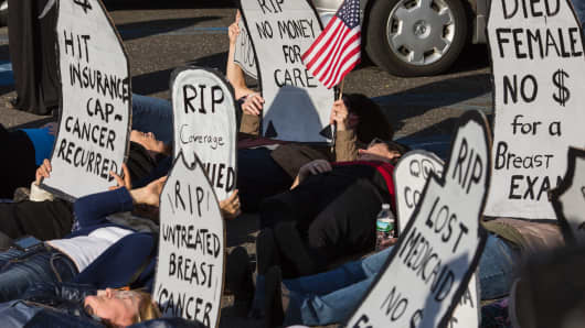 Protesters stage a 'die-in' before a town hall meeting with US Representative Tom MacArthur (R-NJ) in Willingboro, New Jersey on May 10, 2017. MacArthur wrote the amendment to the American Health Care Act that revived the failed bill, delivering a legislative victory for US President Donald Trump.