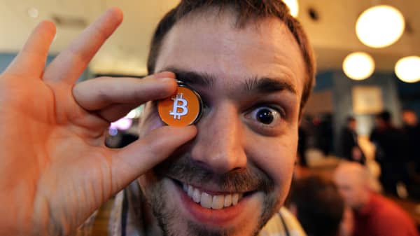 A member of a Bitcoin trading club posing with a Bitcoin medal at the club's meeting in Tokyo.