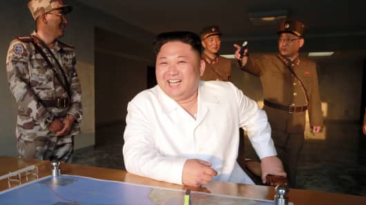 North Korean leader Kim Jong Un reacts during a ballistic rocket test-fire through a precision control guidance system.