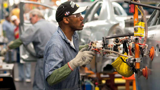 Workers install doors on Chevrolet Malibu and Buick LaCross vehicles at the General Motors plant in Fairfax, Kansas.