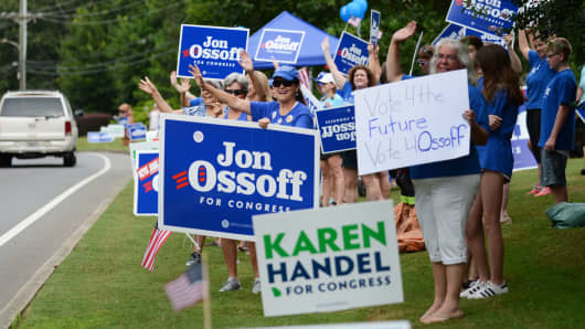Supporters for Georgia 6th Congressional District Democratic candidate Jon Ossoff rally and wave at passing cars outside St Mary's Orthodox Church, Handel's polling place in Roswell.