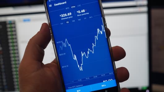 A phone showing an ethereum price chart on the Coinbase exchange platform.