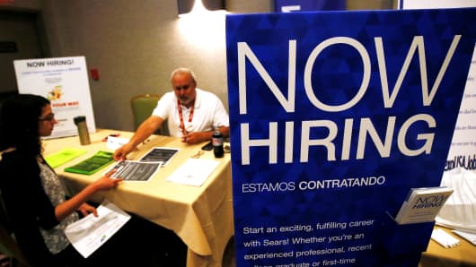 A job applicant (L) talks with a recruiter for Sears at a job fair in Golden, Colorado.