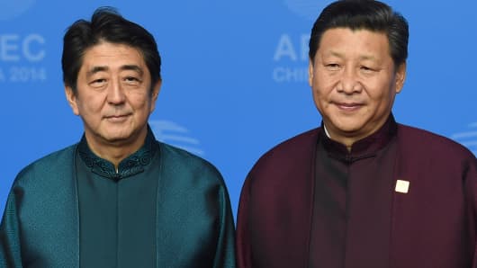 Japan's Prime Minister Shinzo Abe (L) poses with Chinese President Xi Jinping.