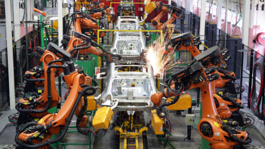 Robotic arms weld body shells in an auto manufacturing plant.