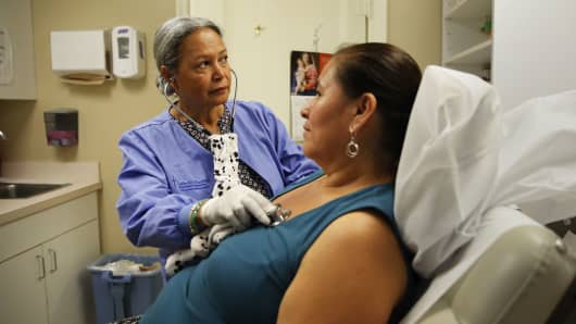 A nurse listens to a client's chest at the Spanish Catholic Center agency of the Diocese of Washington Catholic Charities.