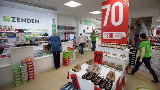 Customers browse discounted shoes inside a Zenden shoe store in Moscow, Russia.