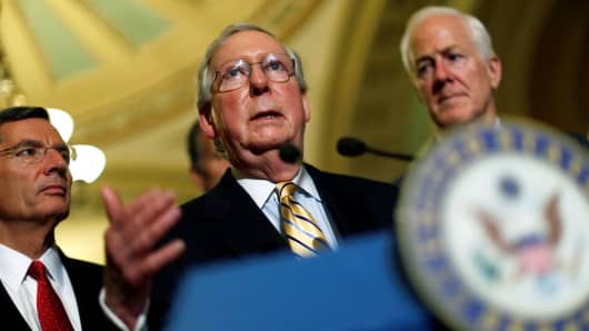 Senate Majority Leader Mitch McConnell, accompanied by Senator John Cornyn (R-TX) and Senator John Barrasso (R-WY), speaks with reporters following the successful vote to open debate on a health care bill on Capitol Hill in Washington, July 25, 2017.