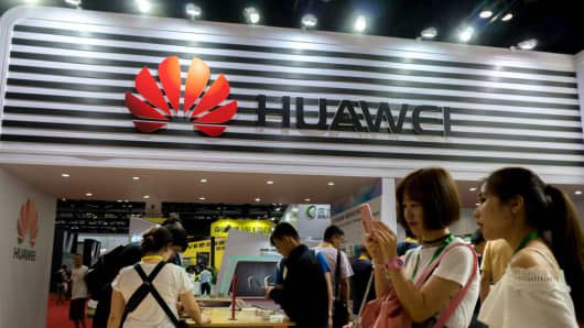 People try using Huawei smartphones at an exhibition.