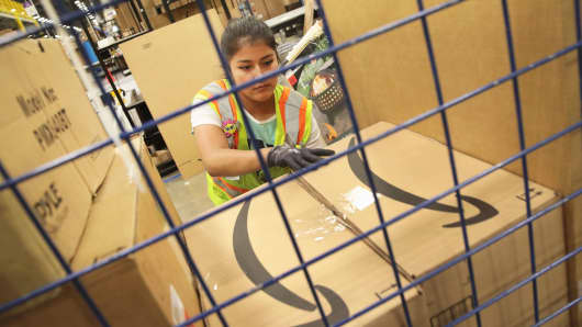 A worker packs customer orders at the Amazon fulfillment center in Romeoville, Illinois.