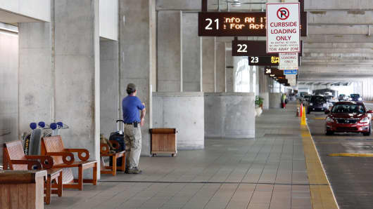 A lone passenger waits to be picked up at the otherwise busy arrivals terminal at Orlando International Airport ahead of the arrival of Hurricane Irma making landfall, in Florida, U.S. September 9, 2017.