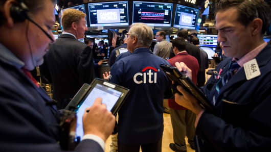 A trader, center, wears a Citigroup jacket while working on the floor of the New York Stock Exchange.