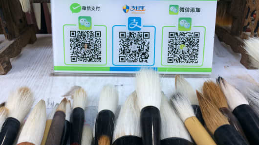 Customers can buy traditional Chinese calligraphy brushes at this Xi’an, China, store using QR payment codes. From left to right: WeChat Pay, Alipay and the QR code for the store’s WeChat account.