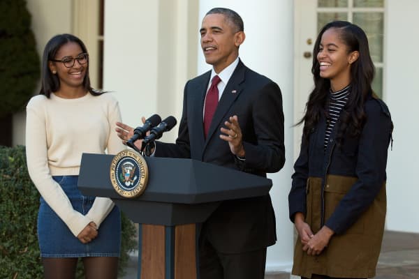 El presidente de Estados Unidos, Barack Obama, habla con sus hijas Sasha (L) y Malia durante la ceremonia anual de perdón del pavo en el Jardín de las Rosas en la Casa Blanca el 25 de noviembre de 2015 en Washington, DC
