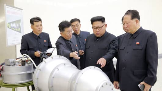 North Korean leader Kim Jong Un (C) looks at a metal casing at an undisclosed location an an undated picture released by North Korea's Korean Central News Agency.