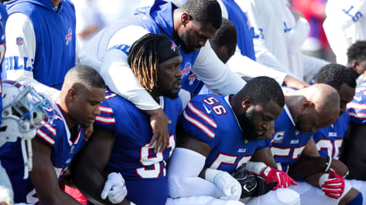 Buffalo Bills players kneel during the American National anthem before an NFL game against the Denver Broncos on September 24, 2017 at New Era Field in Orchard Park, New York.