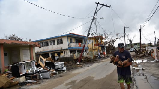 A man walks in a street next to damaged houses in Punta Santiago, in Humacao, in the east of Puerto Rico, on September 27, 2017, one week after the passage of Hurricane Maria.