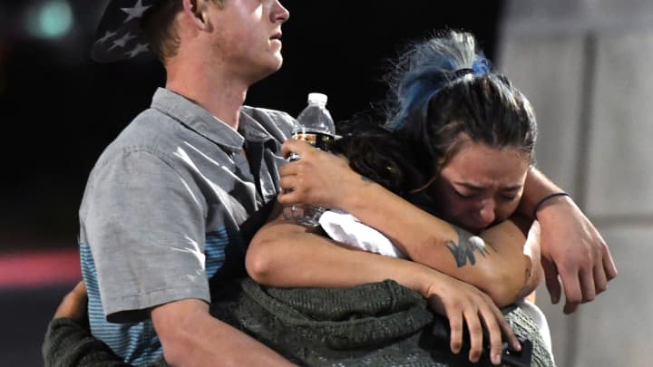 People hug and cry outside the Thomas & Mack Center after a mass shooting at the Route 91 Harvest country music festival on October 2, 2017 in Las Vegas, Nevada.