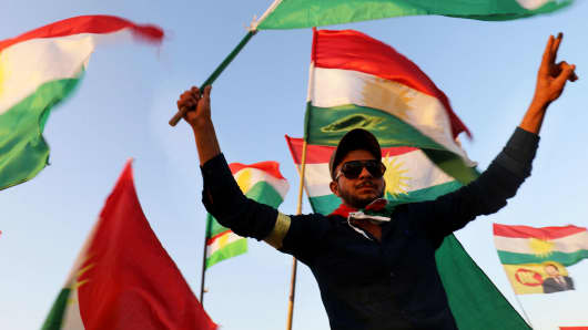 Syrian Kurds wave the Kurdish flag, in the northeastern Syrian city of Qamishli on September 27, 2017, during a gathering in support of the independence referendum in Iraq's autonomous northern Kurdish region.