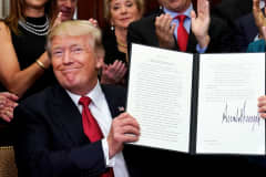 President Donald Trump smiles after signing an Executive Order regarding health insurance plans at the White House in Washington, October 12, 2017.
