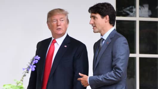 President Donald Trump (L) listens to Canadian Prime Minister Justin Trudeau as they walk towards the Oval Office of the White House in Washington, DC, on October 11, 2017.