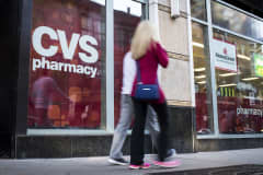 Pedestrians walk past a CVS Health Corp. store in Chicago.