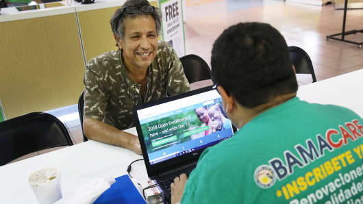 Rudy Figueroa (R), an insurance agent from Sunshine Life and Health Advisors, speaks with Marvin Mojica as he shops for insurance under the Affordable Care Act at a store setup in the Mall of Americas on November 1, 2017 in Miami, Florida.