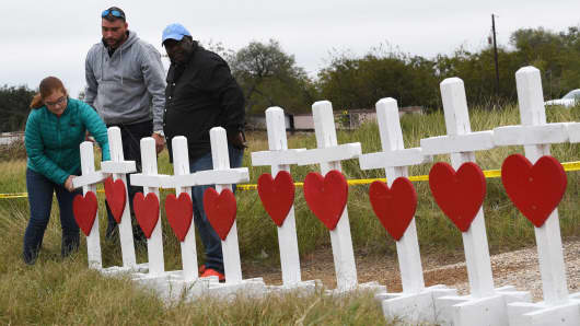 People unload crosses outside the First Baptist Church which was the scene of the mass shooting that killed 26 people in Sutherland Springs, Texas on November 8, 2017.