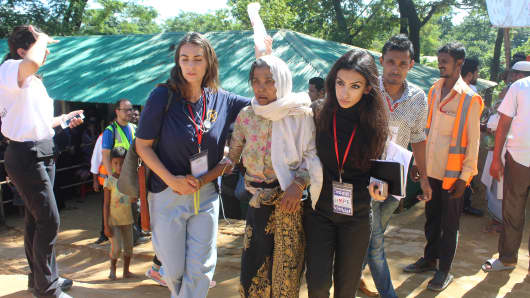 Two workers from the Hope Foundation assist a women at a Rohingya Refugee Camp in Bangladesh.