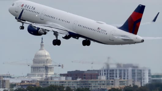 With the U.S. Capitol dome in the distance, a Delta airplane takes off from Ronald Reagan National Airport in Washington, DC.