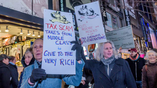 Over a hundred protesters met at Greeley Square in Midtown Manhattan on November 27, 2017 and marched along 34th Street behind a Not One Penny of Tax Cuts for the Rich banner, with Tax Scam signs, Not One Penny signs and giant checks made out from Medicaid or Medicare to billionaires or corporations, to raise awareness against the irresponsible tax plan that cuts Medicare and increases healthcare costs for older New Yorkers.