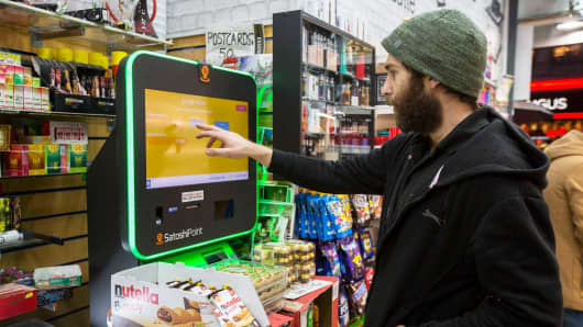 A customer uses a Bitcoin machine in Piccadilly Circus in London.