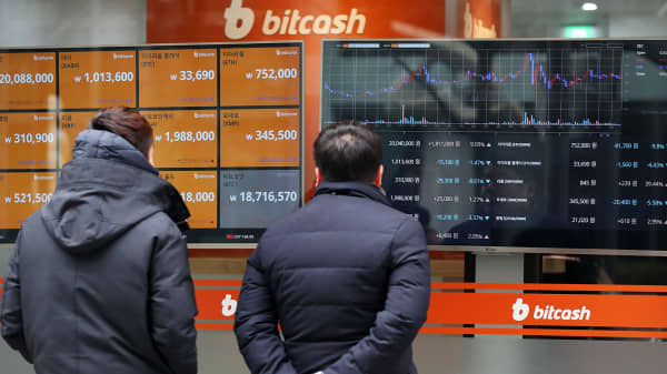 Pedestrian look at monitor showing the prices of virtual currencies at the Bithumb exchange office in Seoul, South Korea, on Friday, Dec. 15, 2017.
