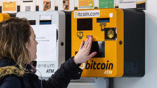 A woman touches an ATM machine for digital currency Bitcoin in Hong Kong on December 18, 2017.